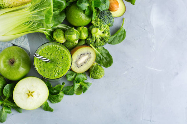 Food and drink, healthy dieting and nutrition, lifestyle, vegan, alkaline, vegetarian concept. Green smoothie with organic ingredients, vegetables on a modern kitchen table. Copy space background