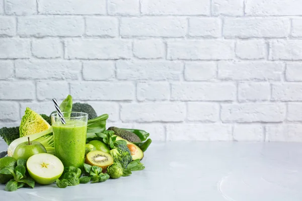 Food and drink, healthy dieting and nutrition, lifestyle, vegan, alkaline, vegetarian concept. Green smoothie with organic ingredients, vegetables on a modern kitchen table. Copy space background