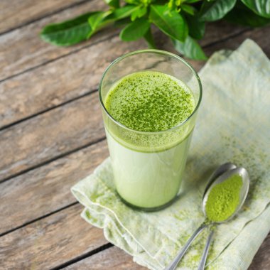 Ahşap bir masa üzerinde matcha yeşil çay latte Cam