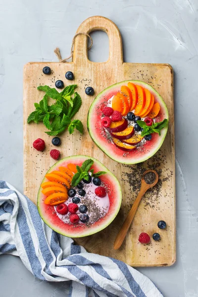 Здоровый летний завтрак с фруктовым салатом и йогуртом в арбузе — стоковое фото