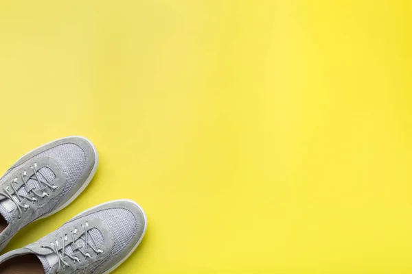 Par de zapatillas masculinas grises sobre fondo amarillo —  Fotos de Stock