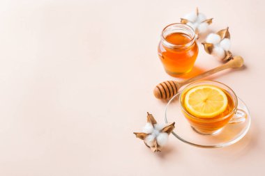 Pastel pembe, kayısı arka plan üzerinde bal ile çay Fincan