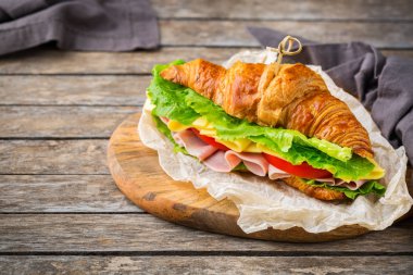 Jambon, peynir, marul ve domatesli taze kruvasan sandviçi.