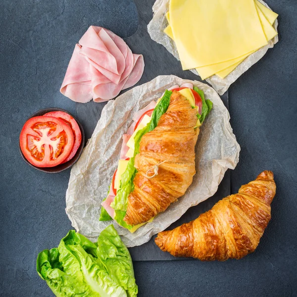 Jambon, peynir, marul ve domatesli taze kruvasan sandviçi.