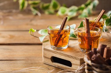 Tahta bir masada sert alkol ve tarçınla vurulmuş.