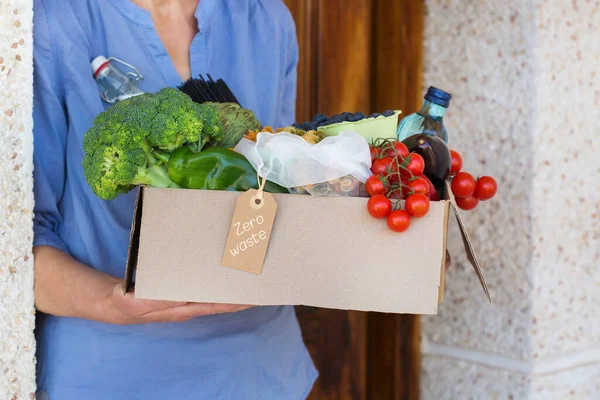 Zero waste no plastic home delivery service. Senior woman holding in hands box of food in recyclable and reusable, eco friendly package. Online internet order, shopping. Sustainable lifestyle concept