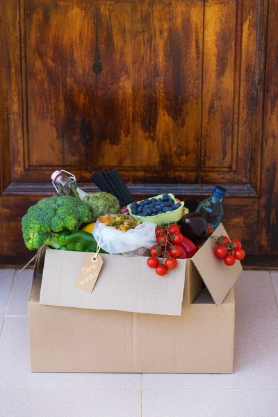 Zero waste no plastic home delivery service. Box of food in recyclable and reusable, eco friendly package near the customer door. Online internet order, shopping. Sustainable lifestyle concept