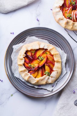 Ev yapımı küçük nektarin, şeftali, kayısı, turta, mevsimlik aromalı açık turta. Sağlıklı ve lezzetli fırın ürünü, olgun meyveli tatlı. Üst görünüm, düz arkaplan