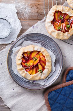 Ev yapımı küçük nektarin, şeftali, kayısı, turta, mevsimlik aromalı açık turta. Sağlıklı ve lezzetli fırın ürünü, olgun meyveli tatlı..