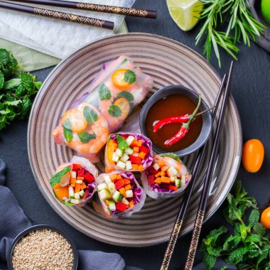 Pirinç kağıdı, havuç, kırmızı lahana, kabak, biber, karides ve kumkatlı bahar ya da yaz ruloları. Lezzetli Asya yemekleri. Üst görünüm düz arkaplan