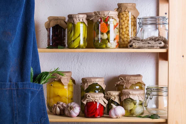 Preserved and fermented food. Assortment of homemade jars with variety of pickled and marinated vegetables on a shelf in the storage room. Housekeeping, home economics, harvest preservation