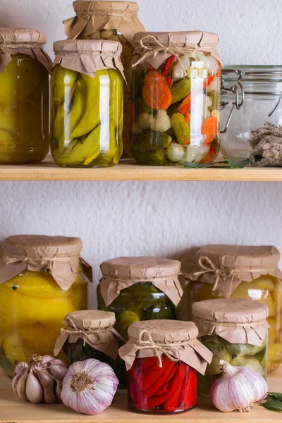 Preserved and fermented food. Assortment of homemade jars with variety of pickled and marinated vegetables on a shelf in the storage room. Housekeeping, home economics, harvest preservation