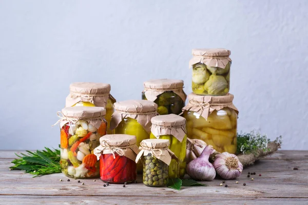 Preserved and fermented food. Assortment of homemade jars with variety of pickled and marinated vegetables on a wooden table. Housekeeping, home economics, harvest preservation