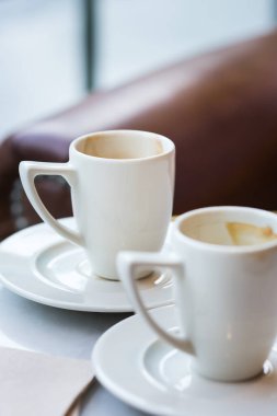 Kafedeki bir masada iki boş kahve fincanı. Doğal ışık ile yaşam biçimi bileşimi