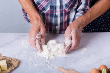 Büyükanne ve küçük çocuğun elleri, torun pişirme, hamur yoğurma, kek, kurabiye. Sıcak mutfakta ailece vakit geçireceğiz. Evde etkinlik.