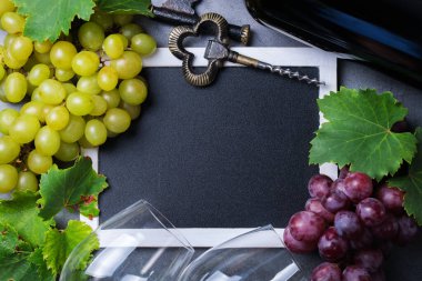 Yiyecek ve içecek, sonbahar hasat konsepti. Şarap tatma, içki içme, sembollü davetiye, üzüm asması, şişe, bardak, tirbuşon. Boşluk siyah arkaplanı kopyala