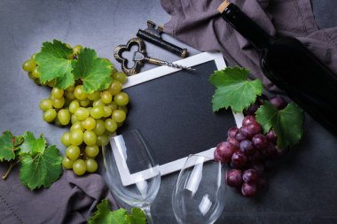 Yiyecek ve içecek, sonbahar hasat konsepti. Şarap tatma, içki içme, sembollü davetiye, üzüm asması, şişe, bardak, tirbuşon. Boşluk siyah arkaplanı kopyala