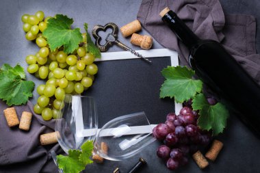 Yiyecek ve içecek, sonbahar hasat konsepti. Şarap tatma, içki içme, sembollü davetiye, üzüm asması, şişe, bardak, tirbuşon. Boşluk siyah arkaplanı kopyala