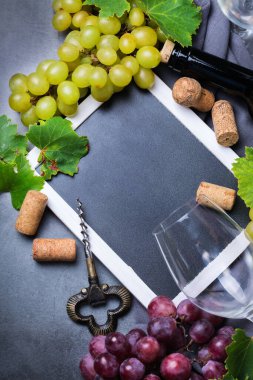 Yiyecek ve içecek, sonbahar hasat konsepti. Şarap tatma, içki içme, sembollü davetiye, üzüm asması, şişe, bardak, tirbuşon. Boşluk siyah arkaplanı kopyala