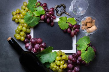 Yiyecek ve içecek, sonbahar hasat konsepti. Şarap tatma, içki içme, sembollü davetiye, üzüm asması, şişe, bardak, tirbuşon. Boşluk siyah arkaplanı kopyala