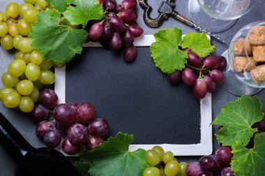 Yiyecek ve içecek, sonbahar hasat konsepti. Şarap tatma, içki içme, sembollü davetiye, üzüm asması, şişe, bardak, tirbuşon. Boşluk siyah arkaplanı kopyala