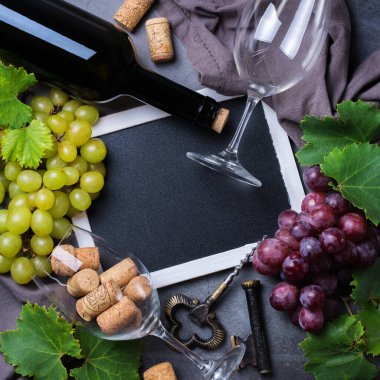 Yiyecek ve içecek, sonbahar hasat konsepti. Şarap tatma, içki içme, sembollü davetiye, üzüm asması, şişe, bardak, tirbuşon. Boşluk siyah arkaplanı kopyala