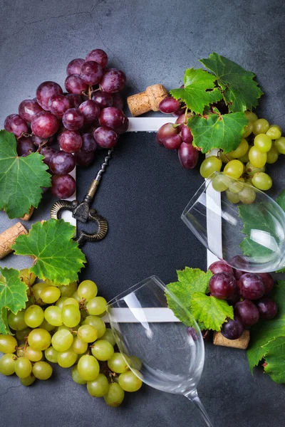 Food and drink, harvest autumn fall concept. Wine tasting, degustation, invitation card with symbols - grape vine, bottle, glasses, corkscrew. Copy space black background