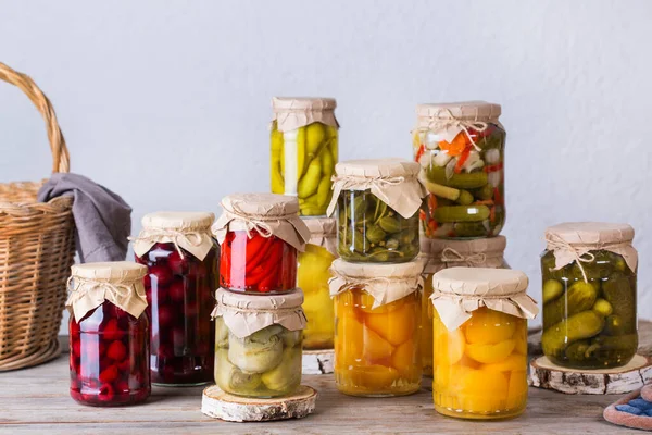 Preserved and fermented food. Assortment of homemade jars with variety of pickled and marinated vegetables, fruit compote on a wooden table. Housekeeping, home economics, harvest preservation