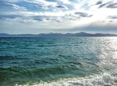 Güzel deniz dalgaları, bulutlu bir günde dağlar.