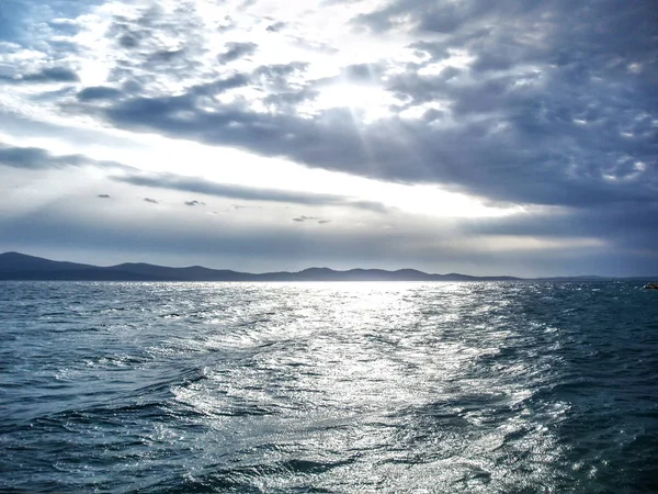 Güneş ışınları ile hafif dalgalar bir denizde shinning.