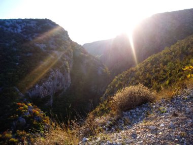 Dağlara güneşli bir gün boyunca geçer bir derin kanyon.