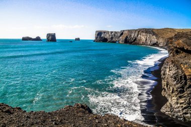 İzlanda, Dyrhlaey, Reynisfjara Beach siyah kum plaj. Kayalar ve kayalıklarla ocean Plajı'nda. İzlanda'nın Güney sahil üzerinde popüler bir turistik spot.