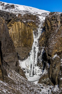 Litlanesfoss valley adlı İzlanda. Ünlü Litlanesfoss şelale Doğu İzlanda'daki Hengifoss yakın. Şelale ve İzlanda Doğu fiyortları, Litlanesfoss Vadisi'nde bazaltik kayalar.