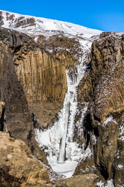 Litlanesfoss valley adlı İzlanda. Ünlü Litlanesfoss şelale Doğu İzlanda'daki Hengifoss yakın. Şelale ve İzlanda Doğu fiyortları, Litlanesfoss Vadisi'nde bazaltik kayalar.