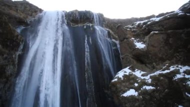 Kış aylarında İzlanda'daki güzel Seljalandsfoss. Kışın, nehir yansıma güzel şelale Seljalandsfoss gündoğumu ışıklar altında donmuş. Seljalandsfoss İzlanda'daki Güney bölgesinde yer alan.