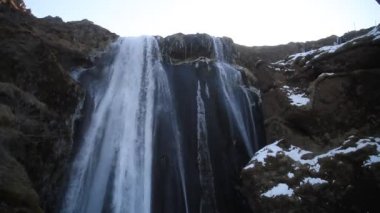 Kış aylarında İzlanda'daki güzel Seljalandsfoss. Kışın, nehir yansıma güzel şelale Seljalandsfoss gündoğumu ışıklar altında donmuş. Seljalandsfoss İzlanda'daki Güney bölgesinde yer alan.