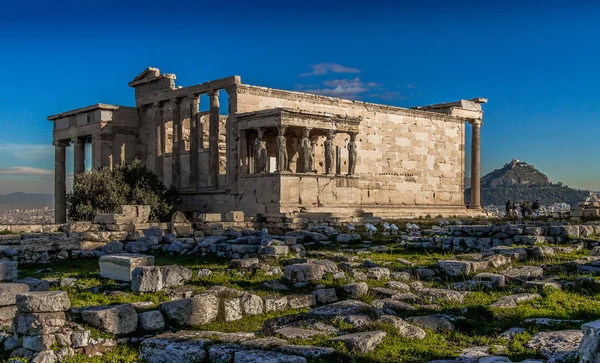 Acropolis of Athens, Greece, with the Parthenon Temple. Famous old Parthenon temple is the main landmark of Athens. View of Odeon of Herodes Atticus, Figures of the Caryatid Porch of the Erechtheion.