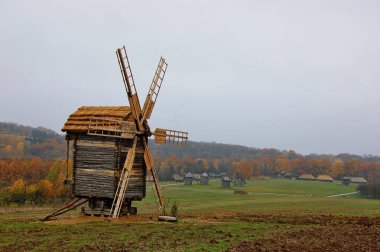 Sonbahar manzarasının ortasında eski bir yel değirmeni.