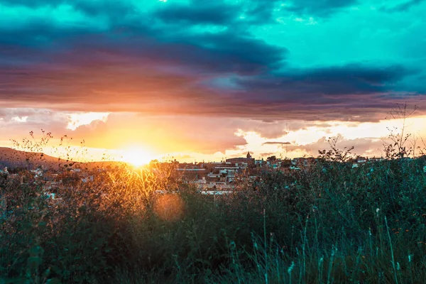 günbatımı turuncu ve mavi bulutlar ve çim ile