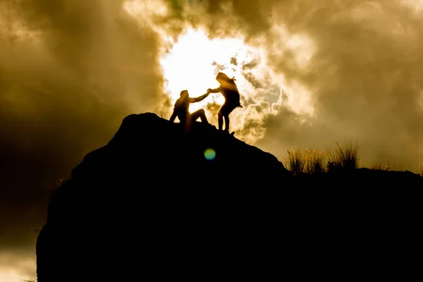 epik bir gökyüzü ile bir dağın tepesinde siluetleri