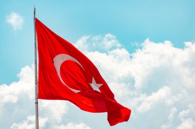 Bayrak sallayarak ile metal direk. Kırmızı bayrak ile hilal ve yıldız, mavi gökyüzü bulutlu içinde geçmiş. Sakinleştirmek doku. Türkiye'nin ulusal bayrak. Turizm için popüler ülke.