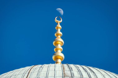 Top of old and beautiful Sultan Ahmed Mosque (Blue Mosque) Ottoman imperial mosque located in Istanbul, Turkey. Moon and sky in background. clipart