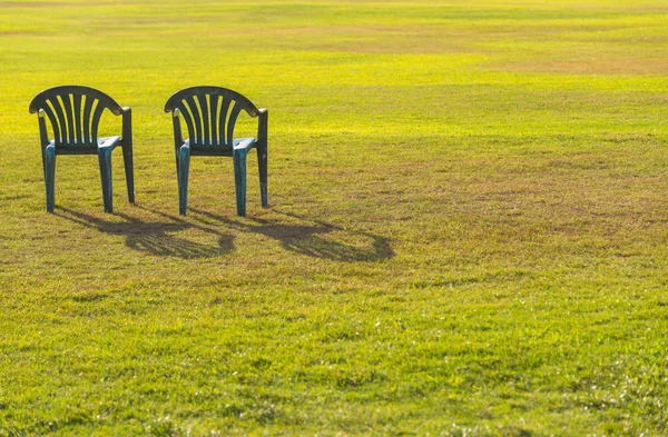 日落时绿色草坪上的两把椅子 — 图库照片