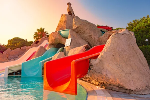 Colored slids in aqua park at resort hotel. Pool in foreground. Place to have fun with family.