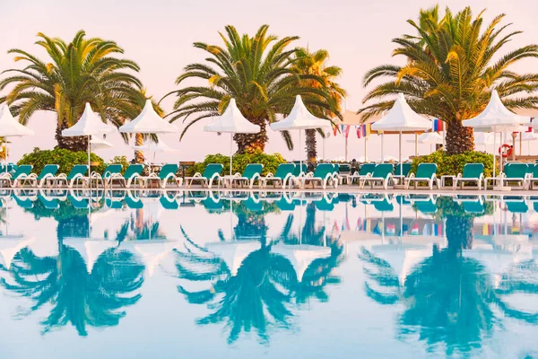 Türkiye'de otel ön plan, beyaz gölge şemsiyeleri, avuç içi ve arka koltuklarda havuzlu