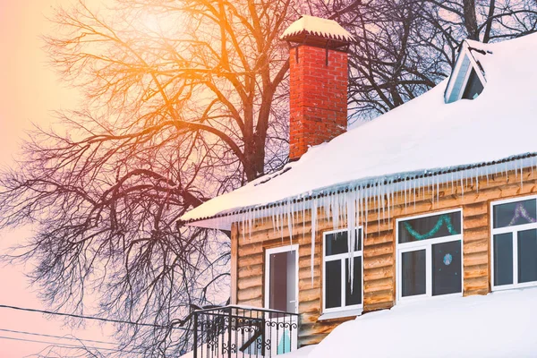 Maison en bois couverte de neige et de glaçons — Photo