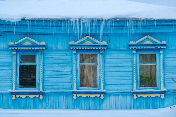 Maison en bois couverte de neige et de glaçons — Photo