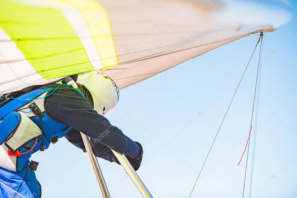 Man prepairing for flight on deltaplane in Germany. Wing in foreground and blue sky in background