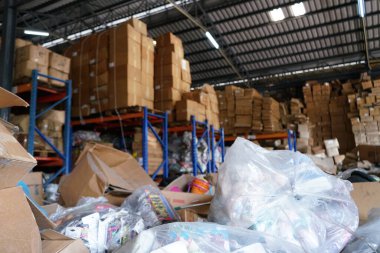 Kötü organize edilmiş deponun bulanık görüntüsü. Bir sürü karışık stoklar ve kutular var.