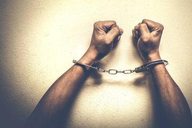 Elleri kelepçeli beyaz çimento yüzeyinde